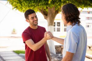 Pair of male friends greeting each other with a handshake